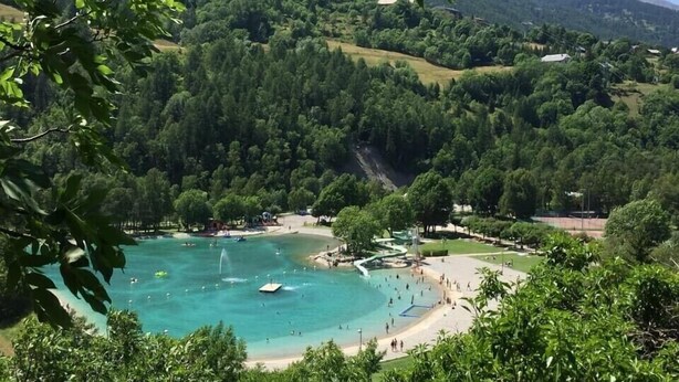 A coastal resort with a beach, a swimming area, and lush greenery. - STUDIO CENTER RESORT LA FOUX D'ALLOS SLEEPS 4 MOUNTAIN CHALET ATMOSPHERE (La Foux d’Allos)