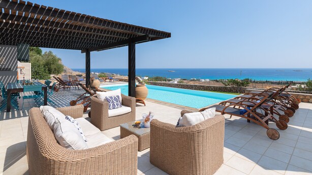 A rooftop terrace with wicker furniture, a pool, and a view of the sea. - Villa Athena Lindos - 6 Bedroom Villa with Private Infinity Pool and Seaviews (Lindos)