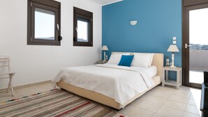 A bedroom with a bed, two bedside lamps, a window, and a door. - Villa Athena Lindos - 6 Bedroom Villa with Private Infinity Pool and Seaviews (Lindos)