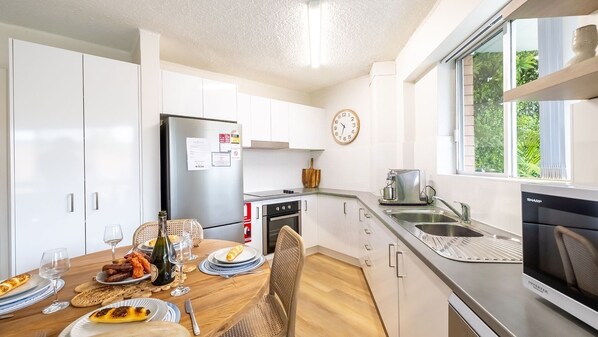 Enjoy meals in the comfort of your accommodation at this kitchen with an oven, compact sink, and ample storage.