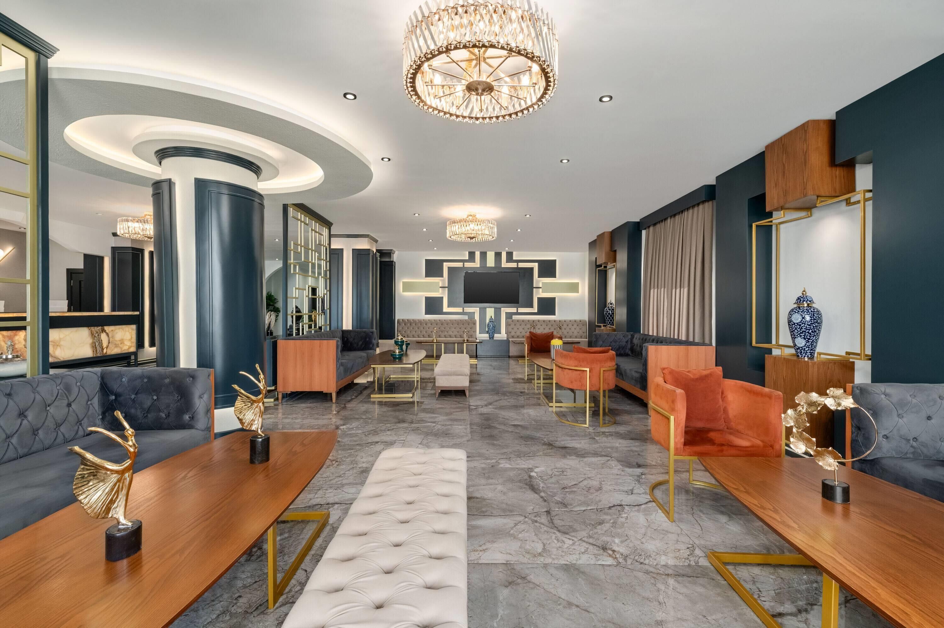 A spacious living area with a modern chandelier, a flat-screen TV, and comfortable seating arrangements.