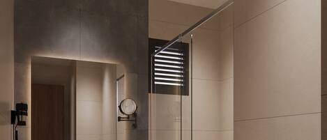 A modern bathroom with a glass shower enclosure, a vanity with a mirror, and a toilet.