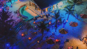 An aerial view of a resort with a pool, outdoor seating, palm trees, and umbrellas. - Oaga Art Resort (Maaranfushi)