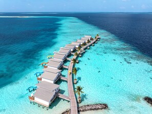 An overwater bungalow resort with a long pier connecting the buildings to the shore. - Oaga Art Resort (Maaranfushi)