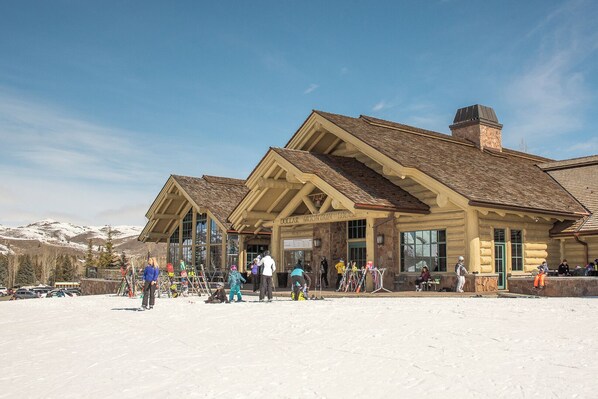 A lodge with a stone facade and wooden beams, featuring a large entrance and a ski slope in the foreground. - The Ridge Condo 2617 - Sun Valley Elkhorn 2BR with Fireplace (Sun Valley)
