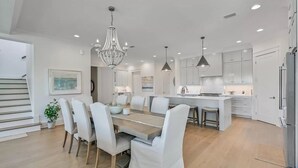 A modern kitchen with white cabinets, a central island, and pendant lighting.