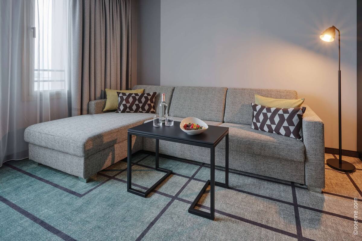 A modern living room with a sofa, a coffee table, and a floor lamp.