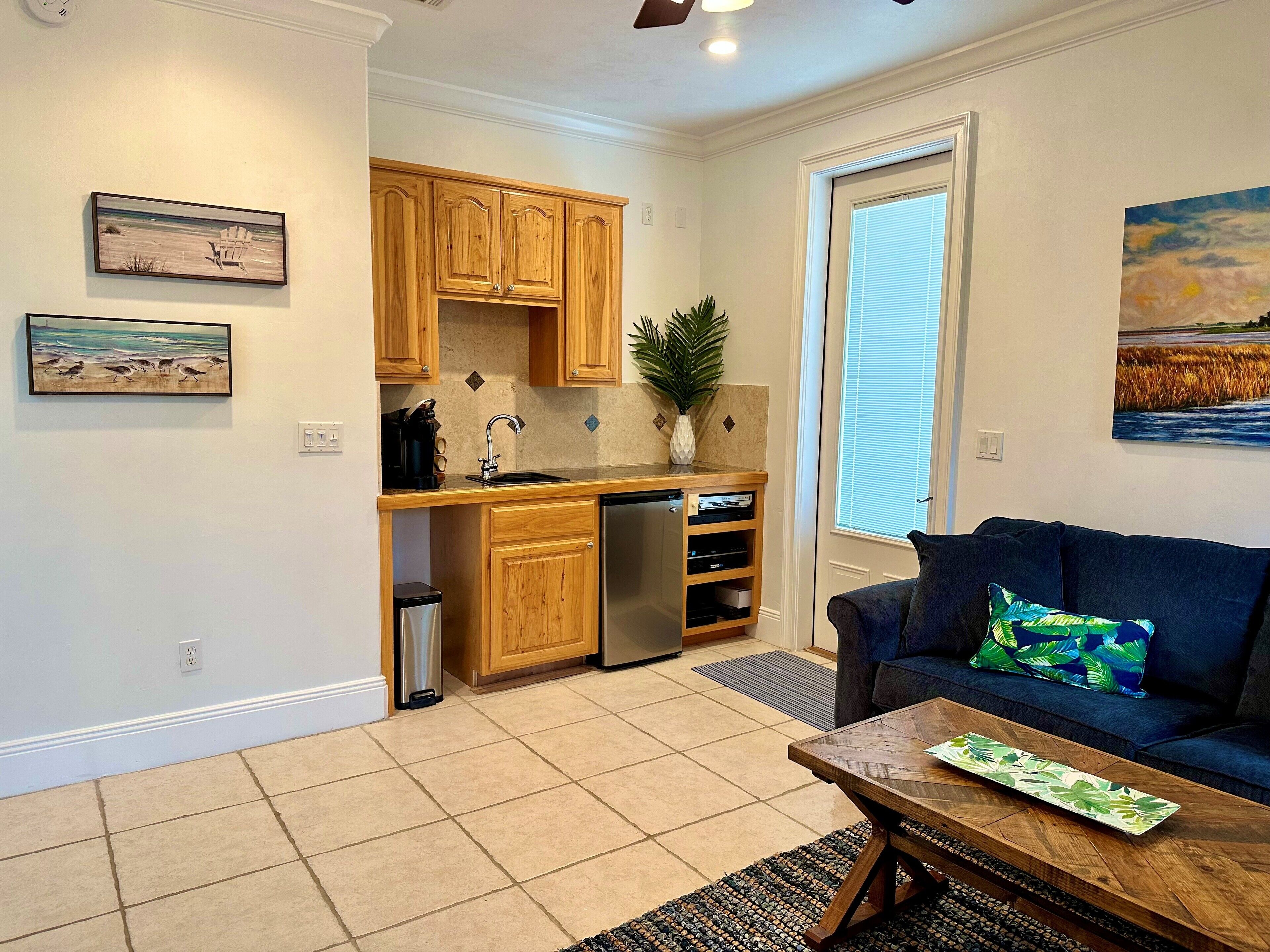 A compact living space with a kitchenette, a sofa, and a coffee table.