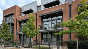 Un bâtiment moderne à l’extérieur en brique et en métal, doté de grandes fenêtres et d’un toit plat.