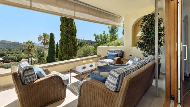 A balcony with wicker furniture, a glass table, and a view of the landscape. - Townhouse with pool and mountain views, just 5 minutes from Pollensa downtown  (Pollensa)