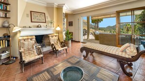 A living room with a fireplace, a large window with a view, and a lounge area with a bench. - Townhouse with pool and mountain views, just 5 minutes from Pollensa downtown  (Pollensa)