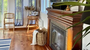 A living room with a fireplace, a television, and a large window with curtains. - Lakehouse w/ stunning views and a swimming pool‼️ (Val-des-Bois)