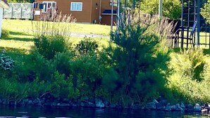 A house with a covered patio and a pond in the foreground. - Lakehouse w/ stunning views and a swimming pool‼️ (Val-des-Bois)