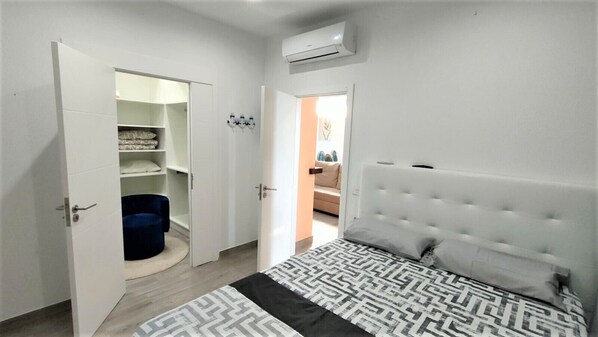A bedroom with a bed, a wardrobe, and an open door leading to another room. - Canarian House with a Jacuzzi, Sauna, and Ocean Views (Barrio Los Menores)