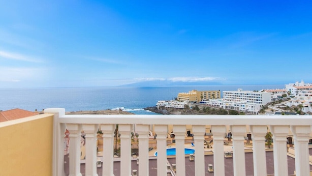 Un balcon avec vue sur la mer et les bâtiments.