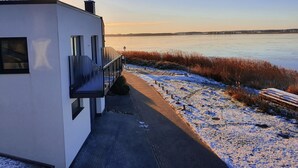 A modern building with a balcony overlooking a frozen lake. - Modern vacation apartment with balcony directly on the Peene (Ziemitz)