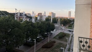 Zona residencial con una calle, coches aparcados y edificios al fondo.
