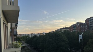 Zona residencial con fila de coches aparcados, árboles y edificios.