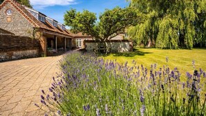 A stone building with a sloped roof, a covered patio, and a garden with lavender. - School House, Burnham Thorpe, Norfolk (Burnham Thorpe)