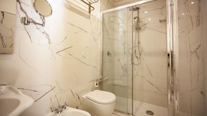 A bathroom with a glass-enclosed shower, a toilet, and a bidet. - Villa Royal B&B (Florence)