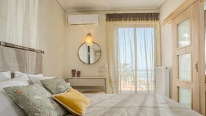Una camera d'albergo con un letto, un comodino, uno specchio e vista sull'esterno.