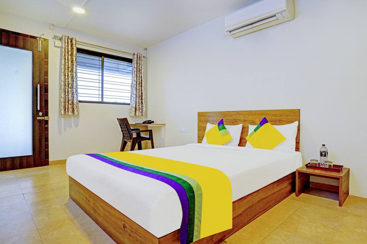 Una habitación de hotel con una cama, un escritorio y una silla.