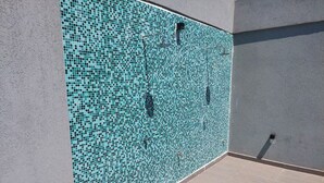 Pared de piscina con azulejos y un desagüe en la parte inferior.