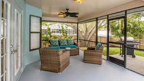 A covered patio with wicker furniture, a ceiling fan, and a view of a backyard with a grill. - Pet Friendly! Huge Heated Pool Quiet Neighborhood Close to Beach Gr8 4 Families! (Sebastian)