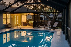 A covered outdoor swimming pool with lounge chairs, a patio area, and a view of the backyard. - Pet Friendly! Huge Heated Pool Quiet Neighborhood Close to Beach Gr8 4 Families! (Sebastian)