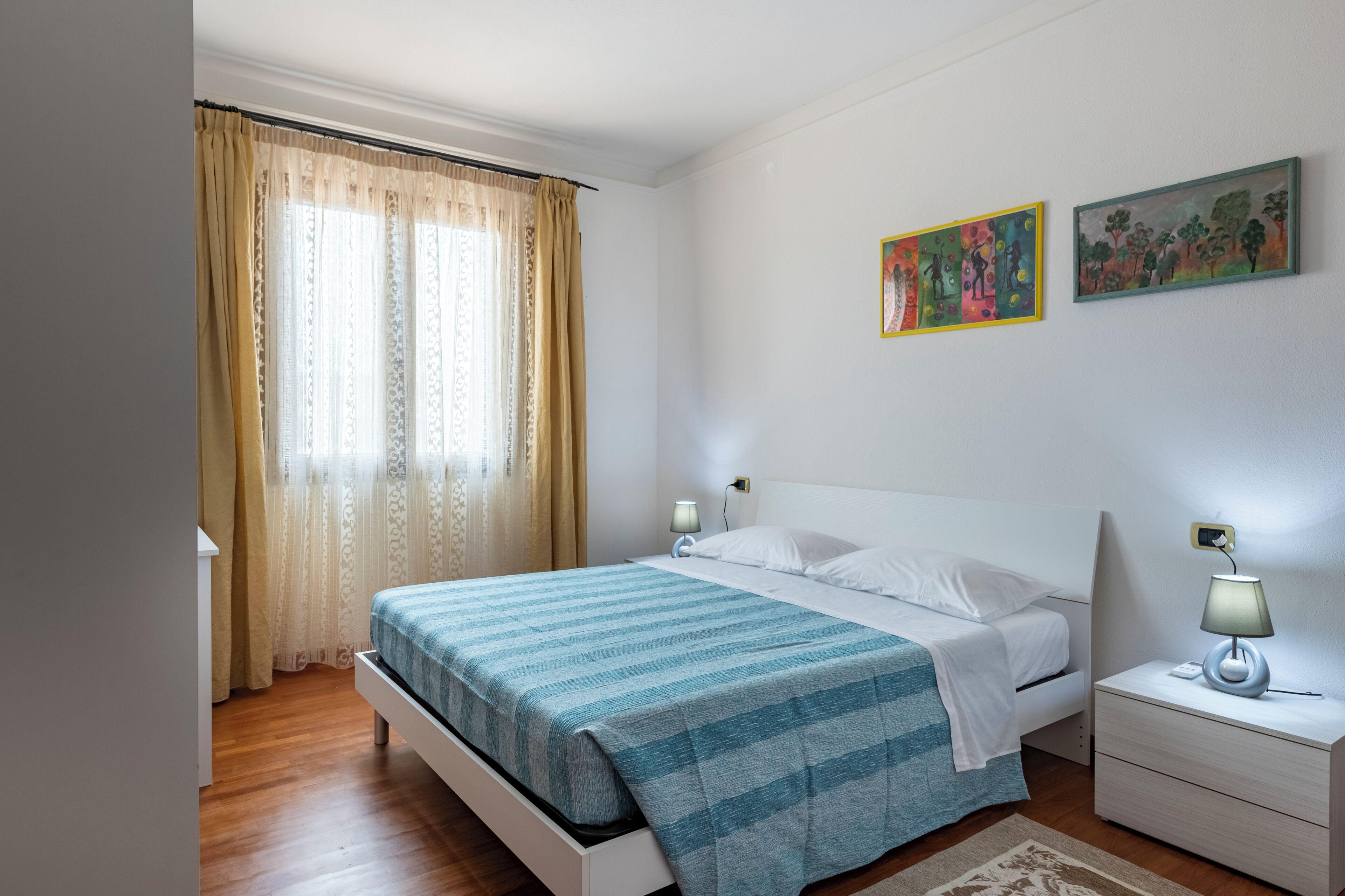 A bedroom with a bed, bedside tables, and a nightstand.