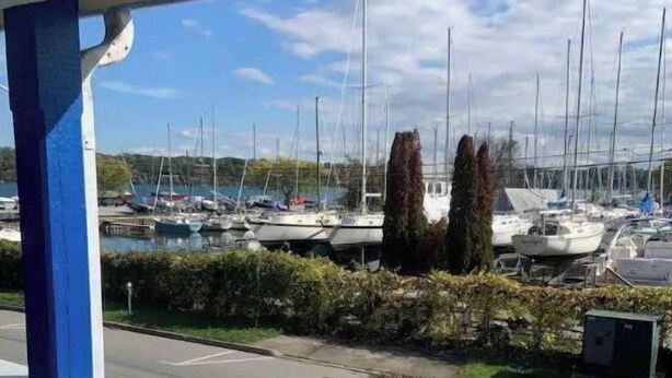 Un balcon donnant sur une marina où sont amarrés plusieurs voiliers.