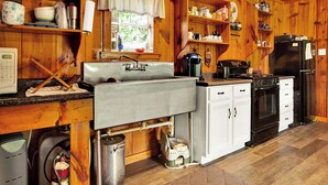A kitchen with wooden cabinets, a sink, a stove, and a refrigerator.
