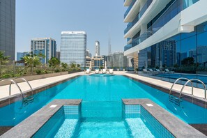 A swimming pool with a cityscape view, including modern buildings and a tall skyscraper.