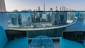 A balcony with a view of a city skyline, including a prominent tower. - GLOBALSTAY. New Apartments in Business Bay (Dubai)