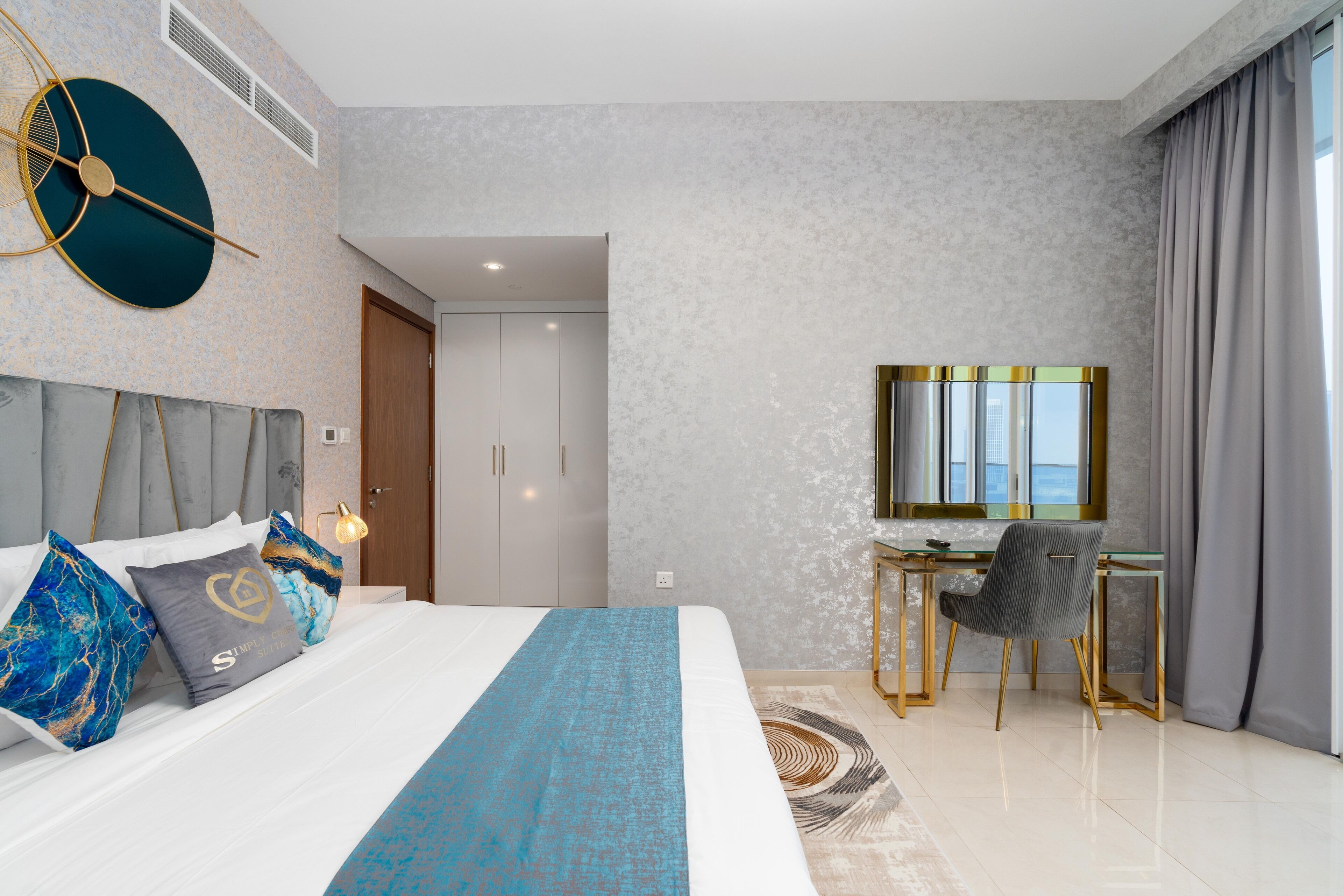 Una camera d'albergo moderna con un letto grande, una scrivania con una sedia, uno specchio ampio e vista sulla città.