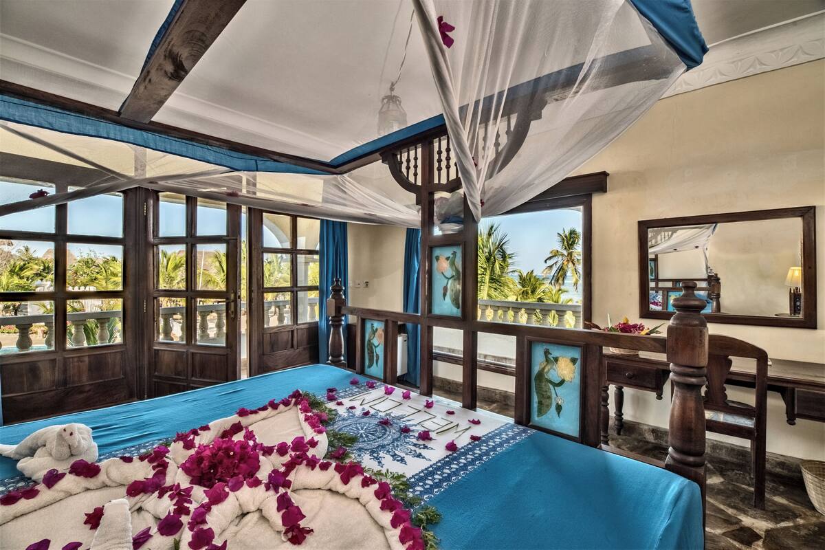 A room with a bed, a desk, and a view of the outdoors.