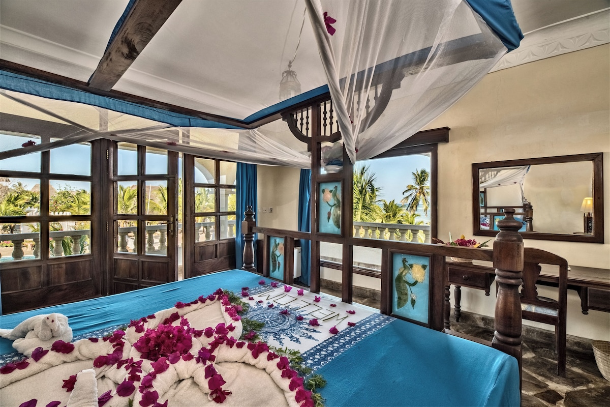 A room with a bed, a desk, and a view of the outdoors.