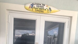 Eine Tür mit beschlagenen Glasscheiben und einem Schild darüber.