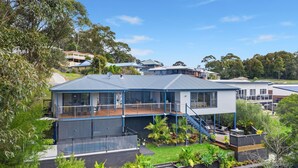 A two-story house with a balcony, a deck, and a garden. - Blue Haven, North Narooma (North Narooma)