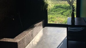 A room with a large window, a plant, and a table. - Villa D'architecte Design au Pied du Luberon (Mérindol)