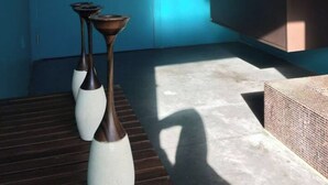 A bathroom with a blue wall, a sink, and two vases on a wooden bench. - Villa D'architecte Design au Pied du Luberon (Mérindol)