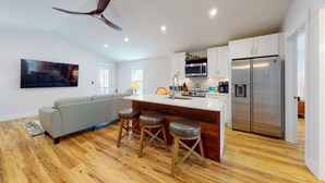 A modern kitchen with a central island, stainless steel appliances, and a ceiling fan. - Quiet Historic Retreat - 15 minutes from Riverwalk (Wilmington)