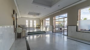 A spacious lobby with a marble floor, a reception desk, and a staircase leading to upper floors. - Hotel Kika (Santa Marta)