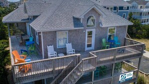 Une maison à deux étages dotée d’un balcon, d’un espace extérieur aménagé pour s’asseoir et offrant une vue sur le quartier environnant.