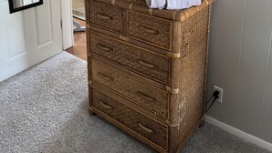 A room with a television on a wicker dresser, a mirror on the wall, and a door leading to another room. - Downtown Getaway 2 (Michigan City)