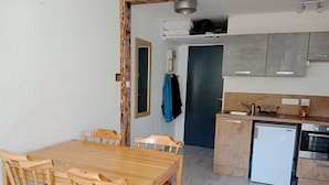 Una cocina compacta con armarios de madera, horno empotrado y lavavajillas.