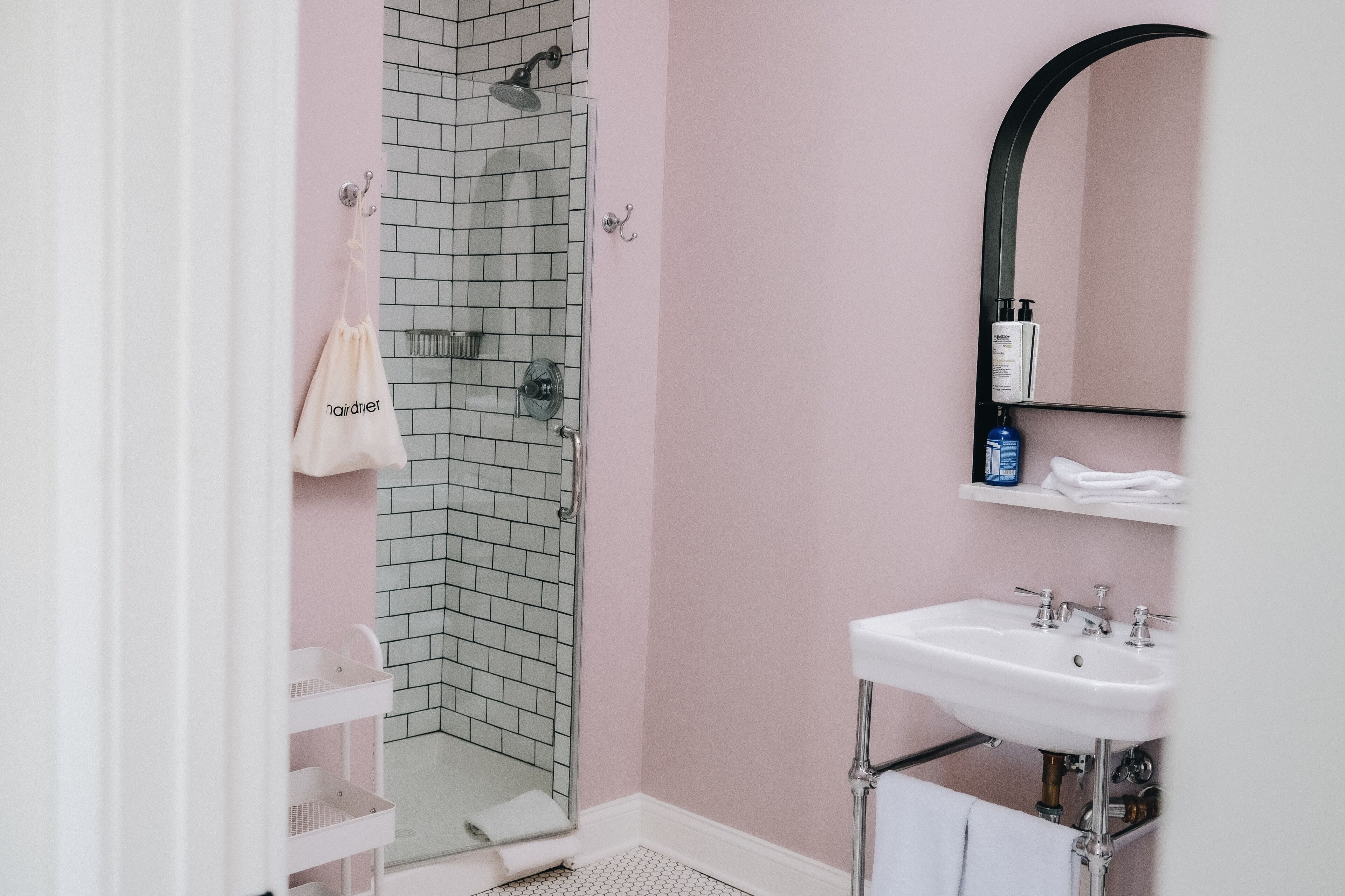 A bathroom with a shower, a sink, and a mirror.