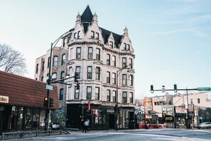 Un edificio histórico en esquina, con amplios ventanales y una entrada destacada.
