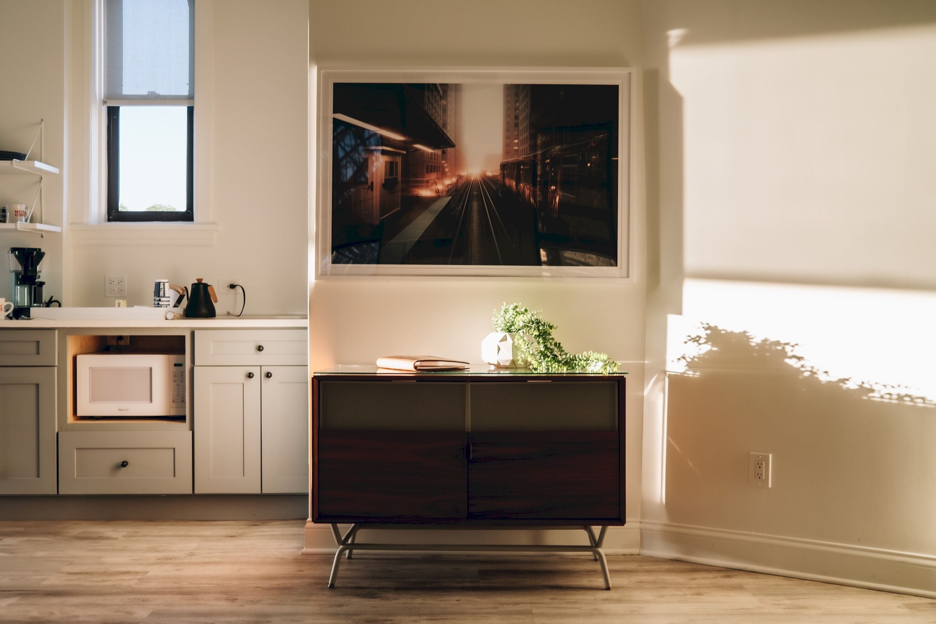 Una cocina moderna con un armario de madera oscura, una encimera blanca y un ventanal grande.