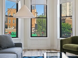 Un salon avec un canapé, un fauteuil et une table basse en verre.